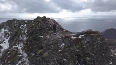 Dağ üstünde ayakta iken kamera çekimleri ile doğa fotoğrafçı turist. Güzel doğa Norveç Lofoten Takımadaları. Hava