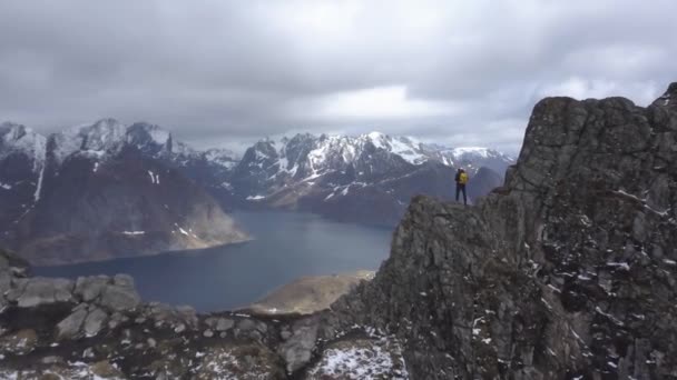 Antenn bilder av manliga vandrare på Bergs topp med utsikt över vackra Lofoten öar landskap i natur sköna, skärgård Norge, — Stockvideo