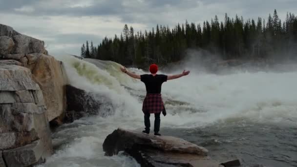 Człowiek robi poza sukces poza przed wodospad — Wideo stockowe