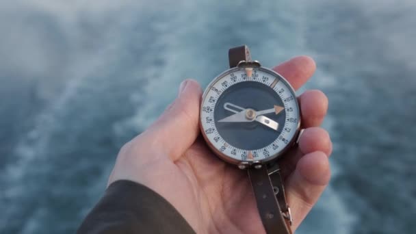 Close-up op kompas instrument in hand gehandschoven. Bergwandelpaden. achtergrond rivier — Stockvideo