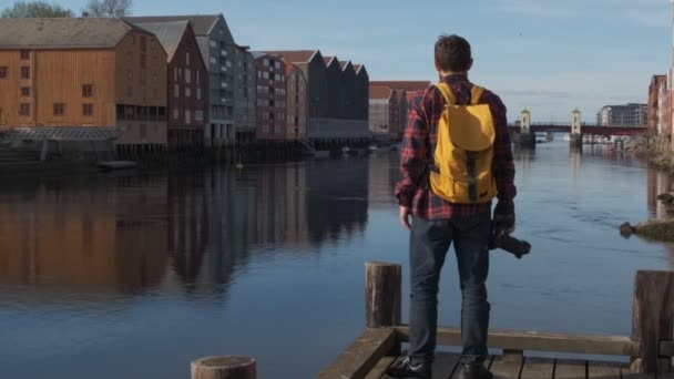 Attrayant jeune beau touriste avec un sac à dos jaune marche dans le centre-ville et de prendre une photo, au ralenti — Video