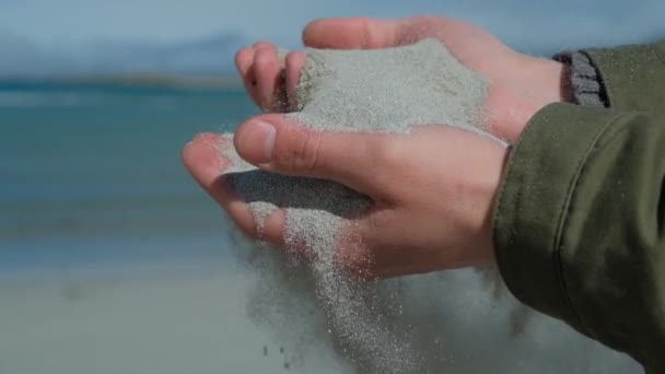 Písek v rukou lidí. Pohled zblízka na písek, který prochází mužskýma rukama. Písek padající z ruky — Stock video