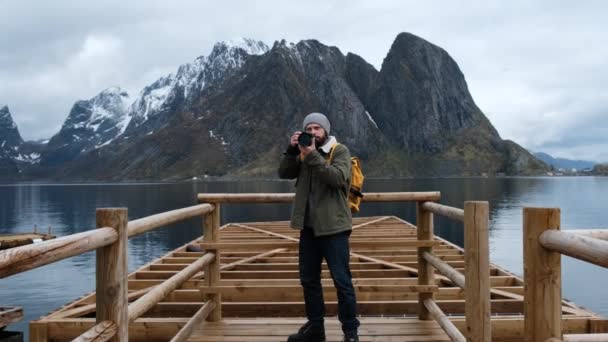 Professionelle Fotograf männlich Aufnahme von Tal mit dslr tragen Rucksack fotografiert malerische Landschaft Natur Reise Abenteuer Norwegen — Stockvideo