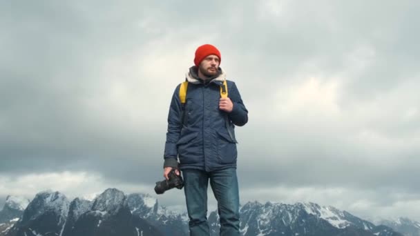 Porträttfotograf ovanpå ett berg. Professionell fotograf hane tar fotografi av dalen med DSLR bär ryggsäck fotografera natur skönt landskap natur resor äventyr Norge — Stockvideo