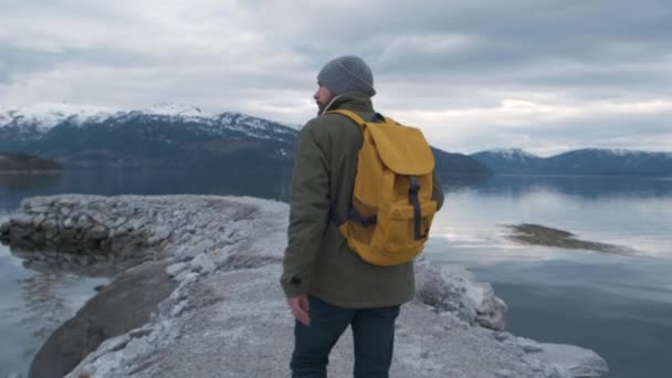 Hipster pasea por el río en Noruega. Hora de la tarde. — Vídeos de Stock