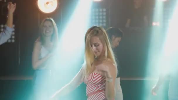 Portret blond meisje dansen op feest met haar vrienden achter — Stockvideo