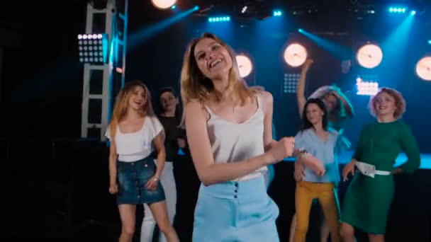 Porträt blondes Mädchen tanzt auf Party mit ihren Freunden dahinter — Stockvideo