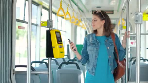 Mujer pagando sin conctacto con teléfono inteligente para el transporte público en el tranvía — Vídeos de Stock