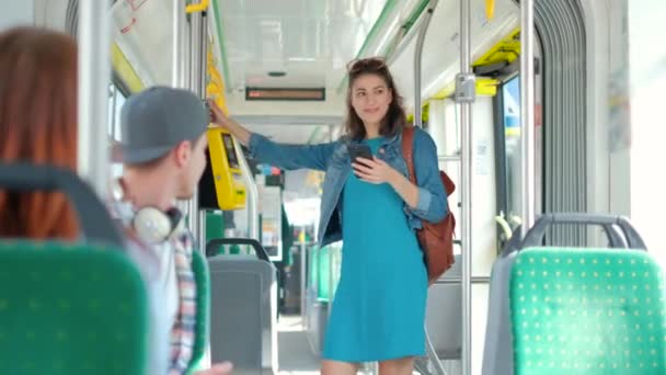 Mujer pagando sin conctacto con teléfono inteligente para el transporte público en el tranvía — Vídeos de Stock