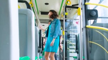 Genç mutlu çift yolcular modern bir tramvayda yürürken toplu taşıma yolculuğunun keyfini çıkarıyorlar.