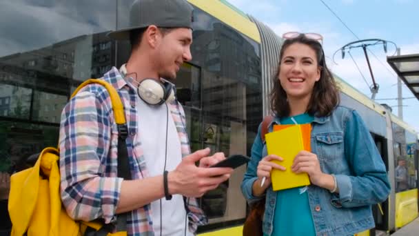 若い男が会い、路面電車の公共交通機関で女の子と話をする — ストック動画