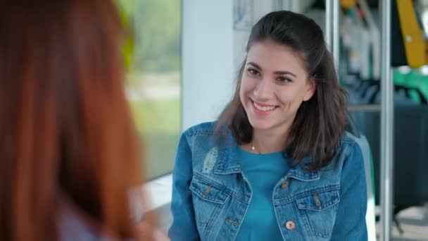 Retrato de mujer joven hablando con un amigo mientras está sentado en un tranvía — Vídeo de stock