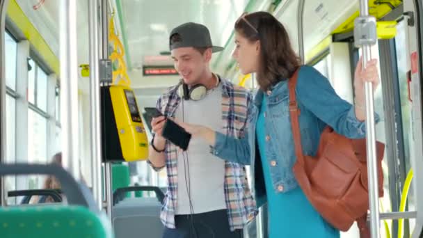 Man and women tourist using phone buy tickets in public transport — Stock Video