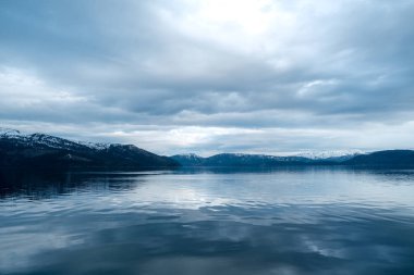 Norveç'te Reinebringen dağının tepesinde sırt çantasıyla yaşam tarzı seyahat macera açık tatil zevk uçurumun kenarında tek başına oturan adam.