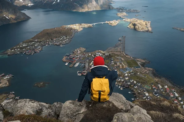 Mies istuu kallion reunalla yksin nauttien ilmakuva reppu elämäntapa matka seikkailu ulkona lomat Norjassa päälle Reinebringen vuori . — kuvapankkivalokuva
