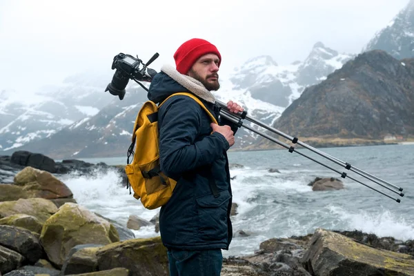 Nuori valokuvaaja seisoo kalliolla rannalla kuvaamassa maisemia Lofotensaarilla Norjassa . — kuvapankkivalokuva