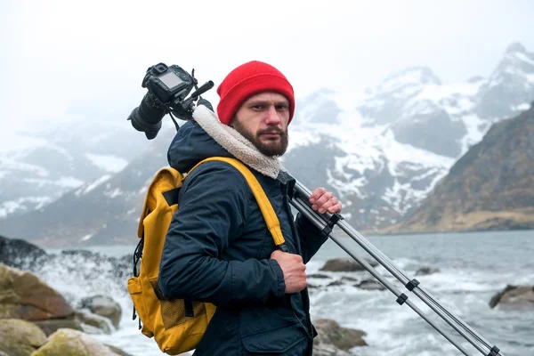 Ung mannsfotograf som står ved fjellet på Beach og fotograferer landskapet på Lofoten . – stockfoto