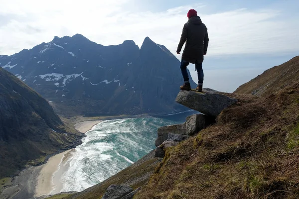 Hombre sentado en el borde del acantilado solo disfrutando de la vista aérea mochilero estilo de vida aventura de viaje vacaciones al aire libre en Noruega cima de la montaña Reinebringen . — Foto de Stock
