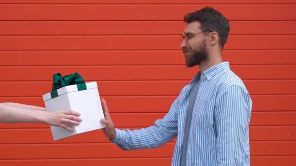 Schöner Mann zeigt Stoppschild mit ernstem und selbstbewusstem Gesichtsausdruck, der nicht als Geschenkbox akzeptiert wird — Stockvideo