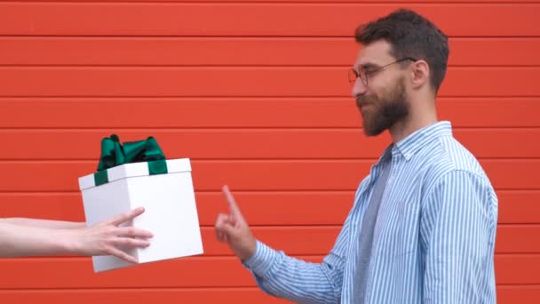 잘생긴 남자는 선물 상자로 허용되지 진하고 자신감 얼굴 표정으로 정지 기호를 보여줍니다 — 비디오