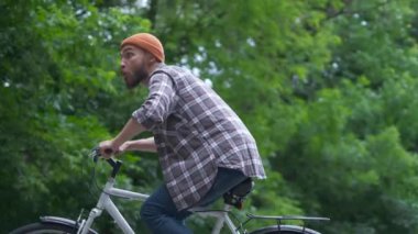 Bisikletli genç adam açık hava eğlencesi yaşıyor. retro vintage tarzı görüntü. Mutlu hipster adam yolda bisiklet sürerken gülümseme. Bisiklet ve macera seyahat yaşam tarzı