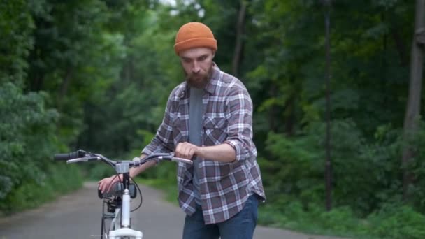 Joven con bicicleta divirtiéndose al aire libre. imagen retro estilo vintage. Feliz chico hipster sonrisa mientras monta en bicicleta en el camino. Ciclismo y aventura viajando estilo de vida — Vídeos de Stock