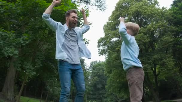 Szczęśliwy broda ojciec i syn. zabawy i skoki podnosząc ręce do góry. — Wideo stockowe