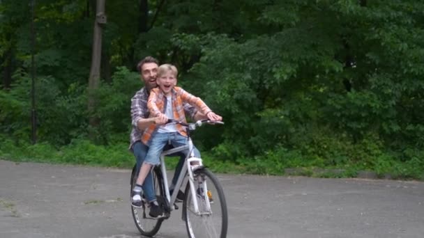 Vader leert zijn zoon om fiets te rijden. vader en zoon familieconcept. — Stockvideo