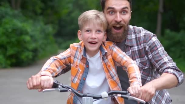 Padre enseñando a su hijo a andar en bicicleta. padre e hijo concepto de familia . — Vídeos de Stock