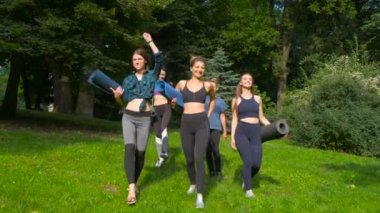 Aktif beş gülümseyen kadın grup egzersiz için gidiyor, parkta yaz sabahı yoga paspaslar tutarak. Aktif yaşam tarzı samimi fitness konsepti. Dinamik hareket. Spor ve sağlıklı.
