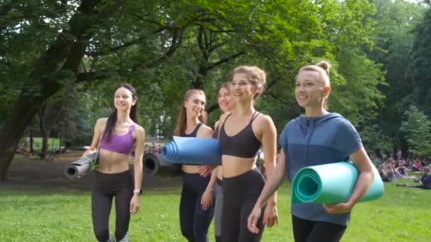 Grupp av aktiva fem leende kvinnliga går för träning, hålla yogamattor på sommaren morgon på Park. Aktiv livsstil uppriktig Fitness koncept. Dynamisk rörelse. Sport och hälsosamma. — Stockvideo