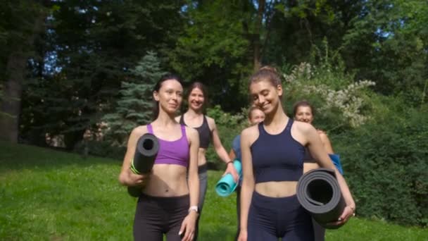 Groep van actieve vijf lachende vrouw gaan voor training, het houden van yogamatten in de zomer ochtend in Park. Actieve lifestyle candid fitness concept. Dynamische beweging. Sporten en gezond. — Stockvideo