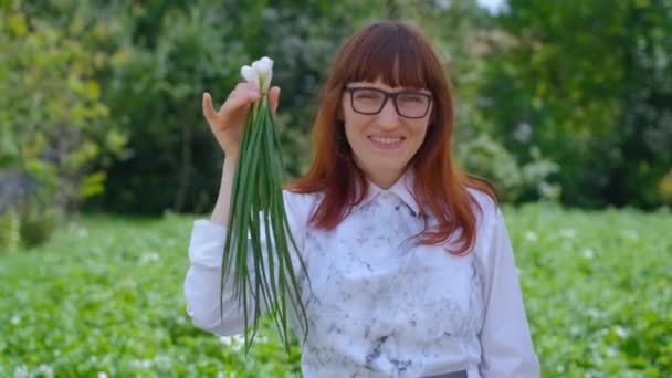 Cebollas verdes en las manos. Mujer elige comida saludable — Vídeo de stock