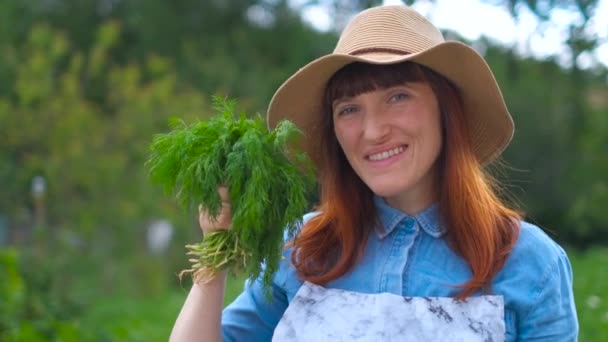 Vrouw is blij met de oogst van de tuin en de tuin plot — Stockvideo