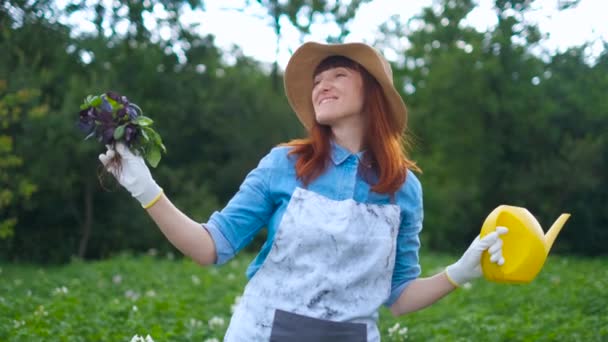 Sorridente giardiniere femminile in posa con le piante di zucchine e guardando fotocamera, agricoltura e giardinaggio concetto — Video Stock