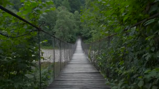 Εύθραυστη ξύλινη γέφυρα πάνω από το ορεινό ποτάμι, κουράγιο να κινηθεί στην άλλη πλευρά — Αρχείο Βίντεο