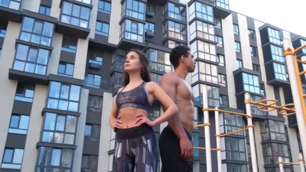 Hombre y mujer atléticos después del ejercicio físico en el gimnasio al aire libre . — Vídeo de stock