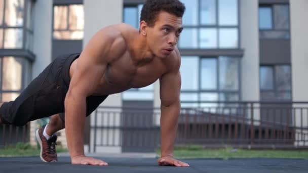 CrossFit man en lifestyle concept. push ups in de buitenlucht doen. achtergrond gebouwen. — Stockvideo