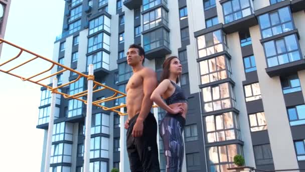 Athletic man and woman after fitness exercise at the gym outdoors. — Stock Video