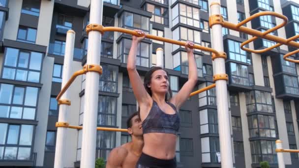 The coach helps the girl to catch up. outdoor gym. — Stock Video