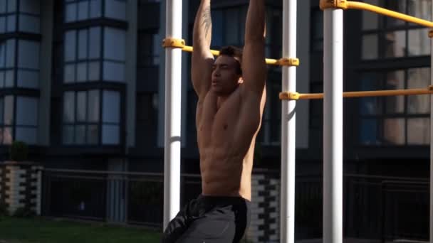 Mladý muskulární muž má trénink venku. Sportovní, fitness, pouliční cvičení. — Stock video