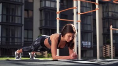 Fit kız sıcak yaz gününde açık tahta egzersiz yapıyor. Dayanıklılık ve motivasyon konsepti