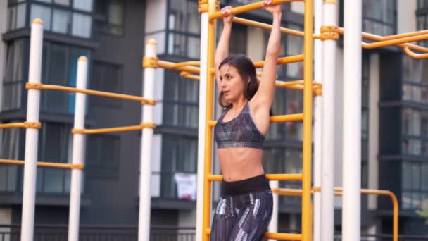 Jong meisje het beoefenen van Calisthenics door het verhogen van zijn benen de sportschool buitenshuis. — Stockvideo