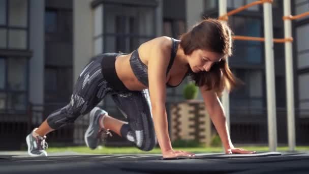 La chica levanta la pierna durante un entrenamiento con una vista frontal — Vídeos de Stock