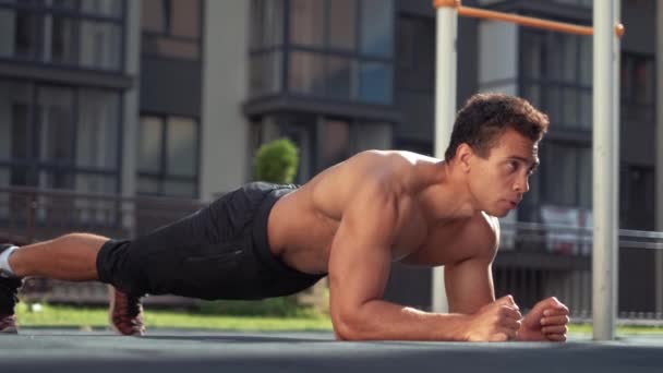 Portrait of handsome caucasian male runner doing push ups in urban setting — Stock Video