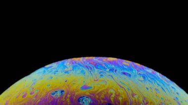 hareket halindeki bir sabun köpüğünün çok renkli irisi. siyah arka plan.