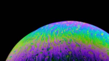 hareket halindeki bir sabun köpüğünün çok renkli irisi. siyah arka plan.