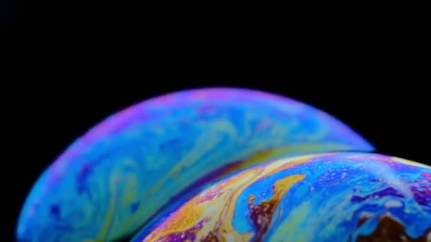 Macro disparo de una burbuja de jabón crea un fondo colorido y negro — Vídeos de Stock