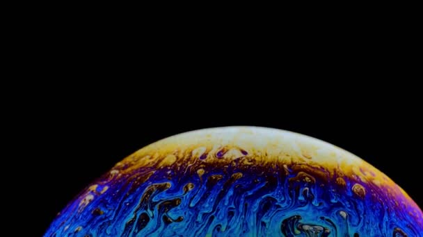Макро знімок мильної бульбашки створює барвистий і чорний фон — стокове відео