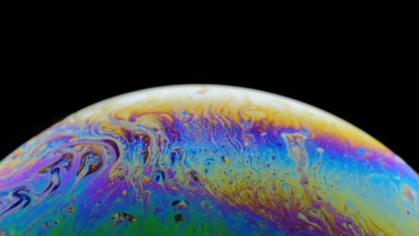 Bulle de savon arc-en-ciel sur fond sombre. Gros plan de la surface colorée — Video